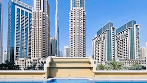 Edifício residencial alto com uma piscina em primeiro plano.