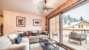 A modern living room with a sofa, coffee table, and artwork on the wall. - Rivulet - Comfortable apartment in Châtel (Châtel)