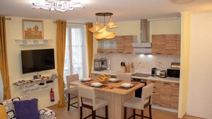 Un salon moderne avec un téléviseur, un canapé et un coin repas.