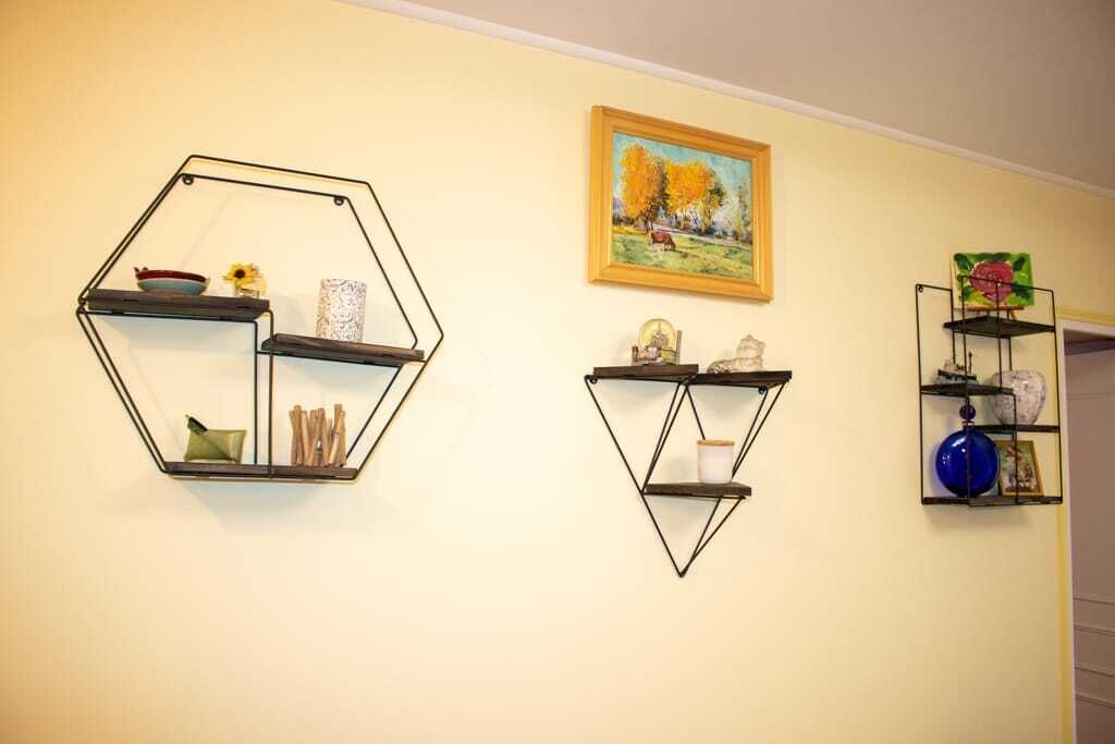Three hexagonal wall shelves with various decorative items.