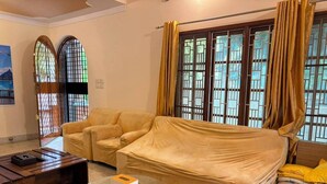 Una sala de estar con un sofá, un sillón y una mesa de centro de vidrio.