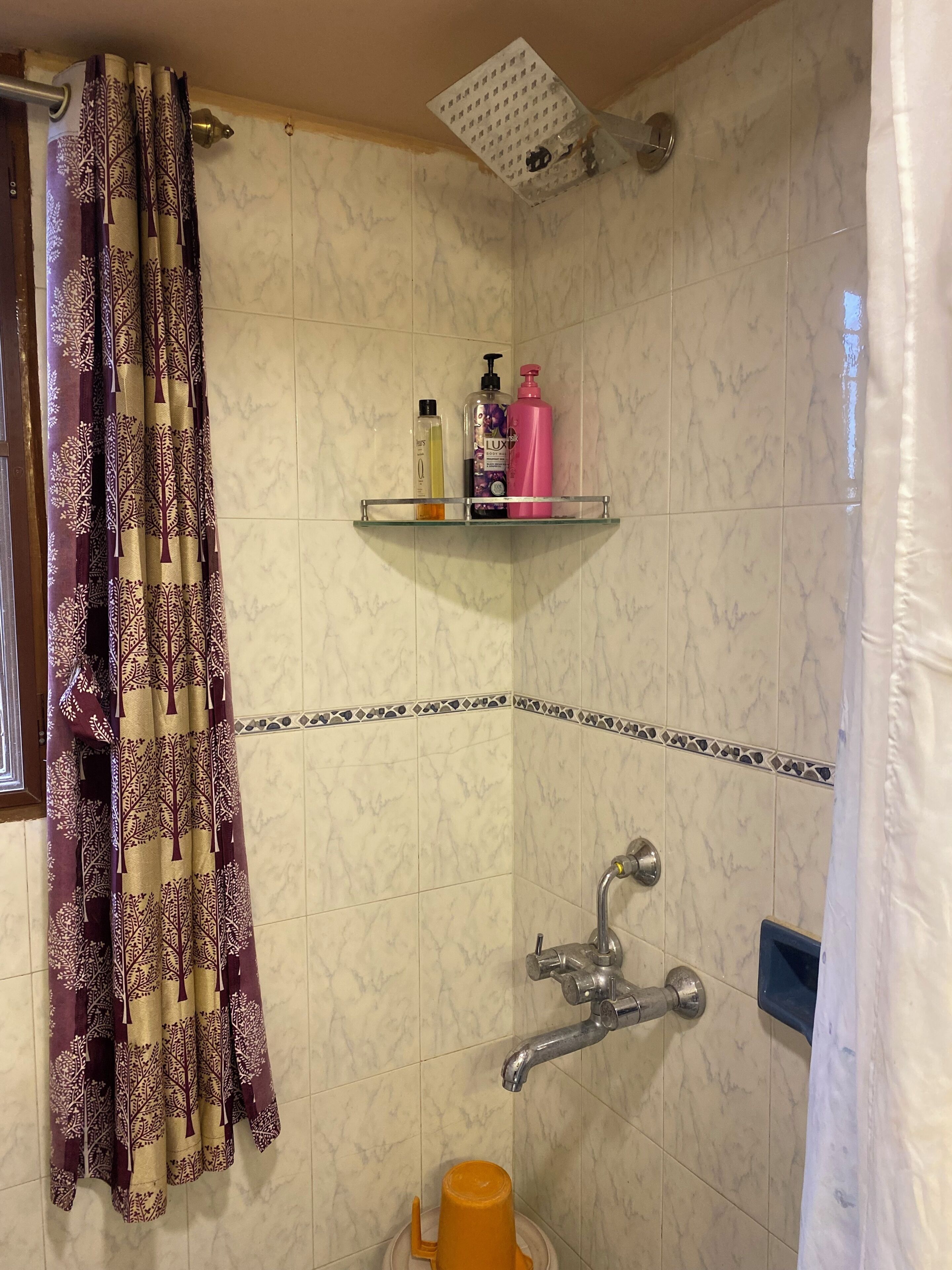 Une salle de bain équipée d’une douche, de toilettes, d’un lavabo et d’une étagère contenant des articles de toilette.