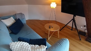 Un salon moderne avec un canapé bleu clair, une petite table en bois et un lampadaire.