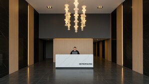 Un mostrador de recepción moderno con encimera de mármol y la palabra "METROPOLITAN" escrita en él.
