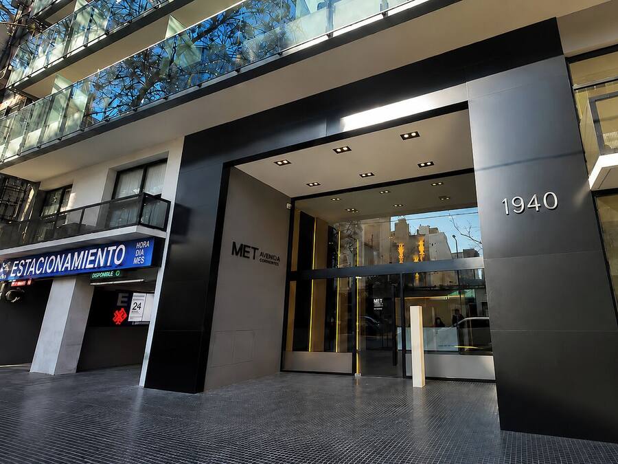 A modern building entrance with a glass facade, a sign for 'MET AVENIDA CORRIENTES,' and the year '1940' displayed.