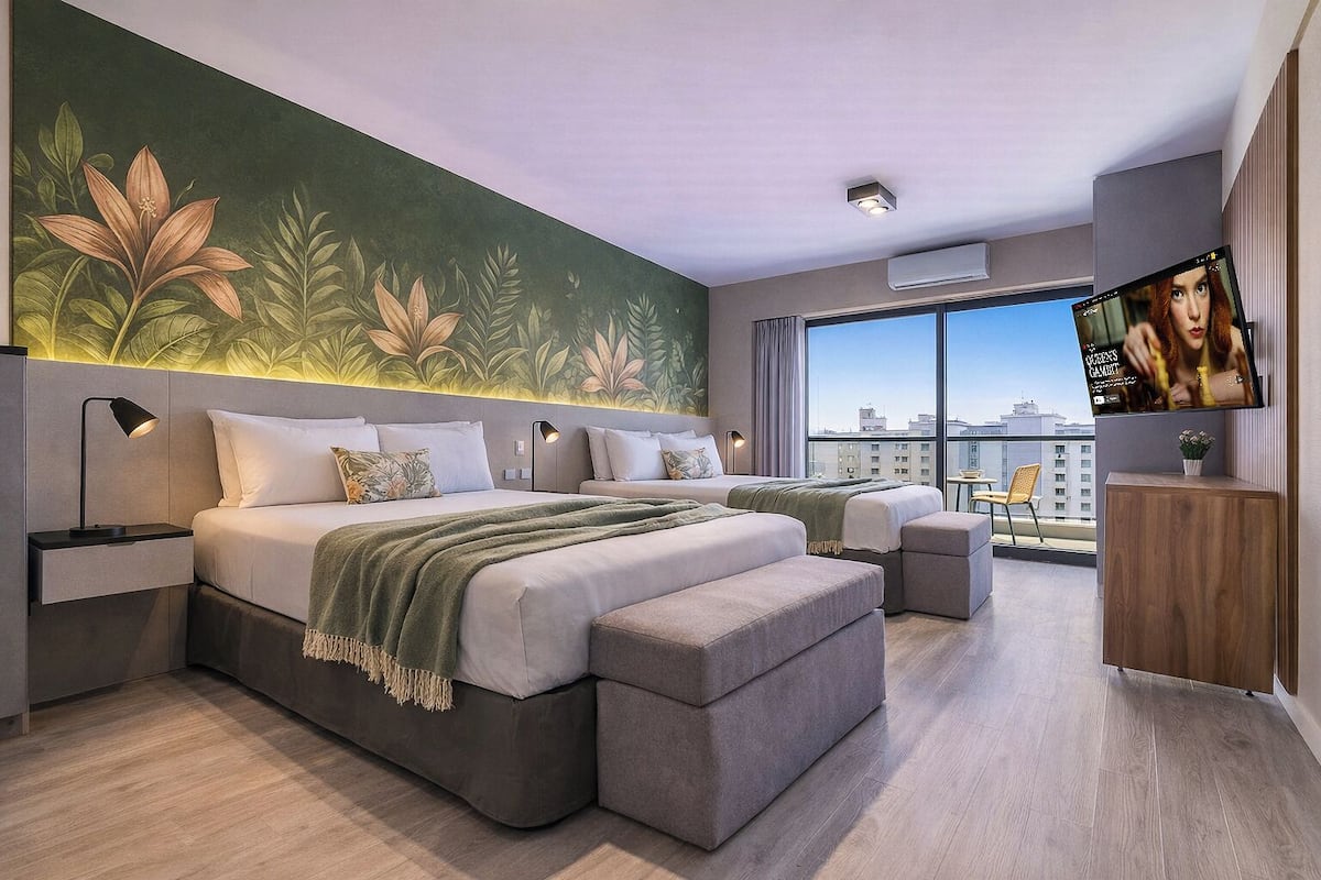 A modern hotel room with a large bed, a smaller bed, a TV, and a city view.