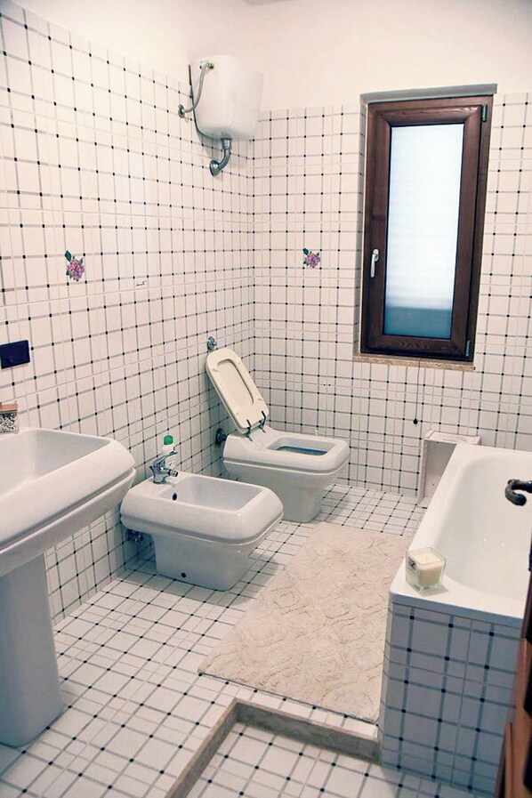 A bathroom with a toilet, bidet, and bathtub. - Villa il Profumo degli Aranci (Eboli)