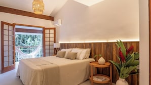 Une chambre à coucher avec un lit, une table de chevet et une vue sur l’extérieur.