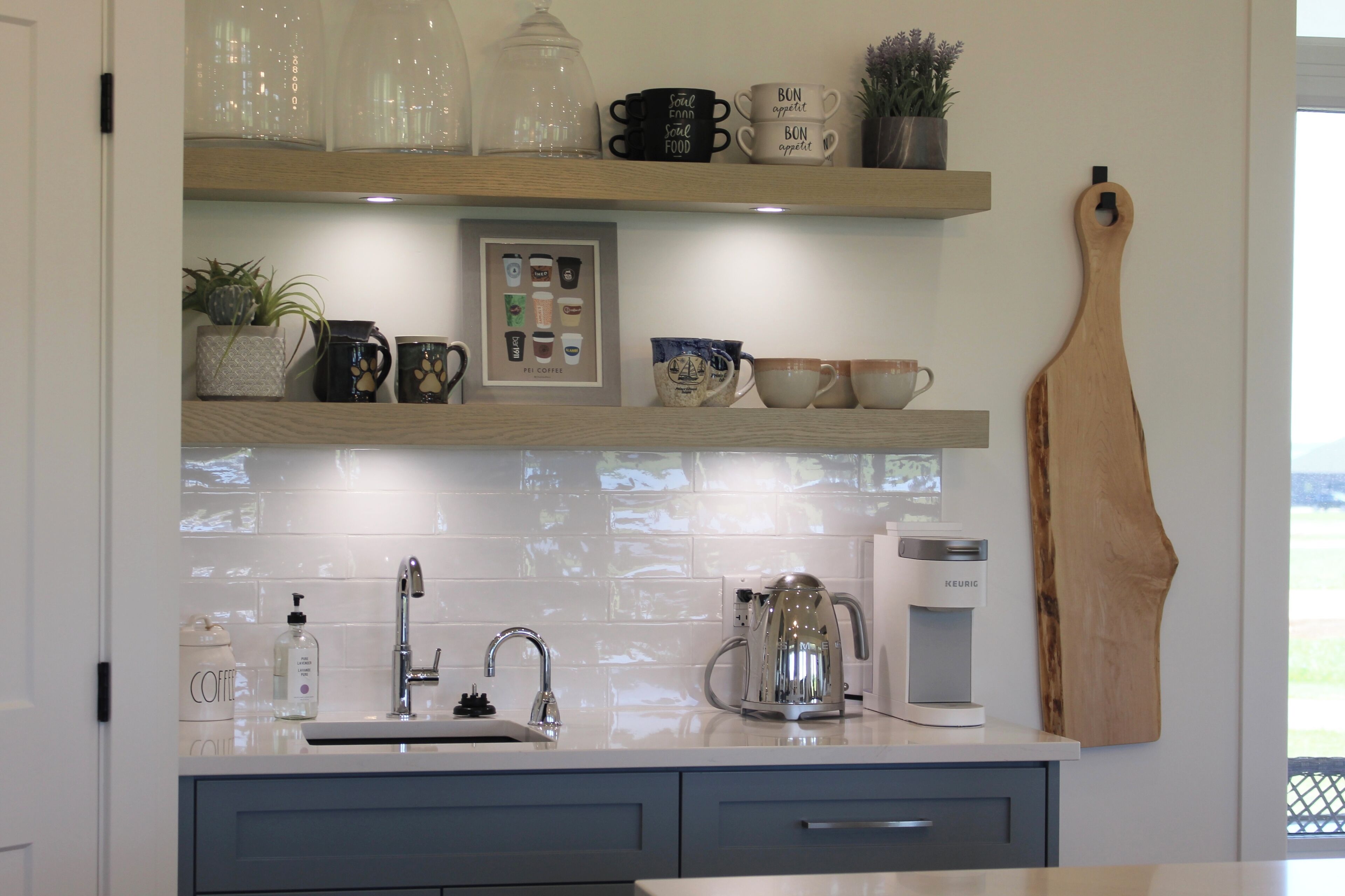A kitchen with a white countertop, a coffee maker, and a kettle.