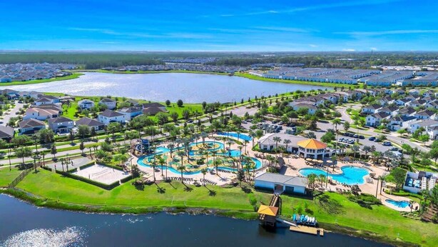 Zona residencial con un amplio complejo de piscinas, casas y una masa de agua.
