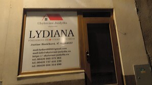 A sign for 'LYDIANA' with contact information and a website URL.