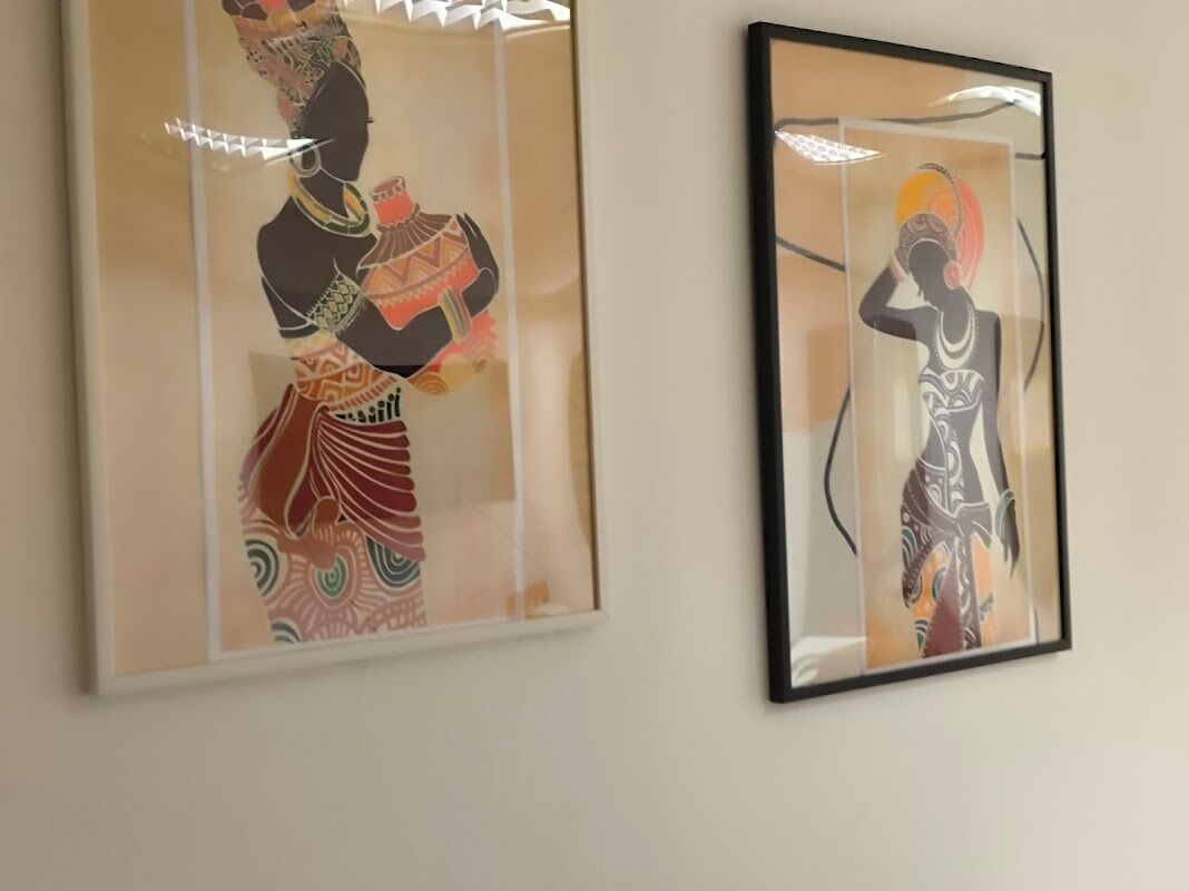 Deux œuvres d’art encadrées sont accrochées au mur.