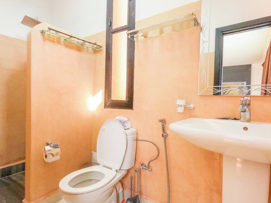 A bathroom with a toilet, sink, and mirror.