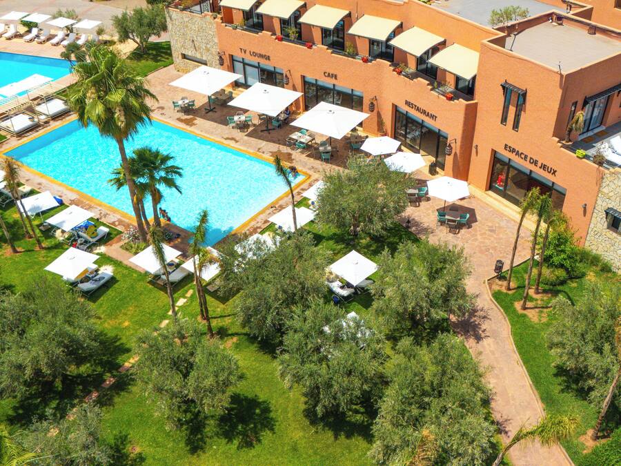 Un resort con piscina, mobiliario exterior y restaurante.