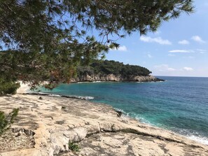 A coastal landscape with rocky terrain and a clear view of the sea. - Sunrise Sunset Seaview Walk to Vis Iconic Beaches (Vis)