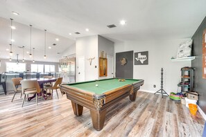 Relax in this stylish space with a pool table, comfortable seating, and a bar area.