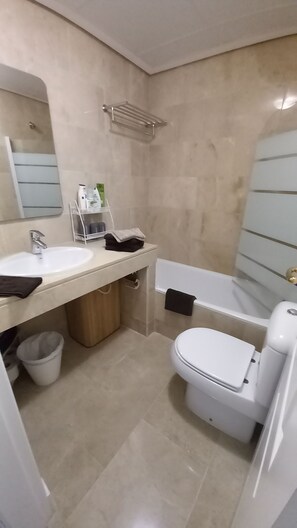 Bathroom features a dual sink vanity with a mirror and a bathtub.