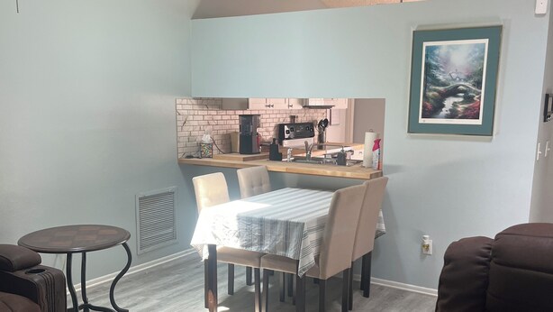 A compact living space with a dining area, a kitchenette, and seating. - Charming 2-bedroom house with WiFi, AC in fabulous Deltona , Florida (Deltona)