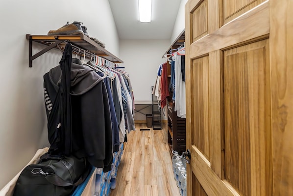 A narrow hallway with wooden flooring, a shoe rack on the left, and a wooden wardrobe on the right.