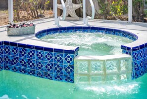 A hot tub with a blue tiled exterior and a starfish decoration.