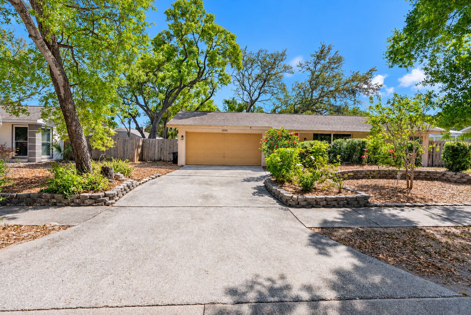 A residential driveway leading to a garage with a number 1004 garage door.