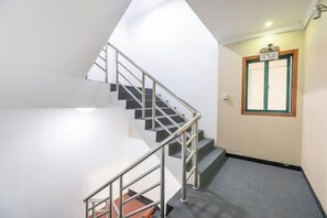 A staircase with metal railings leading to a landing. - Xilaige Hostel (Shanghai)