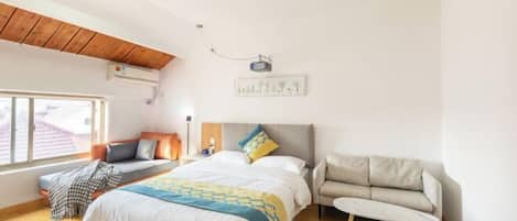 Un dormitorio con cama, sofá, ventana y ventilador de techo.