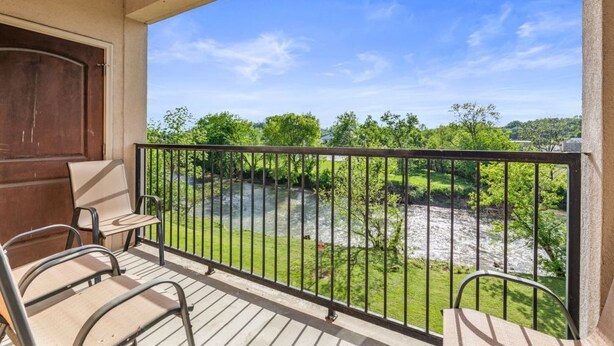 A balcony with a view of a river and greenery. - Pigeon River View #204 (Sevierville)