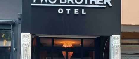 Exterior del Hotel Dos Hermanos con un letrero que indica que no hay estacionamiento.