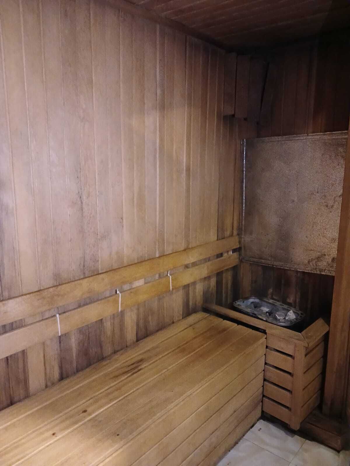 A wooden sauna with benches and a bench seat.