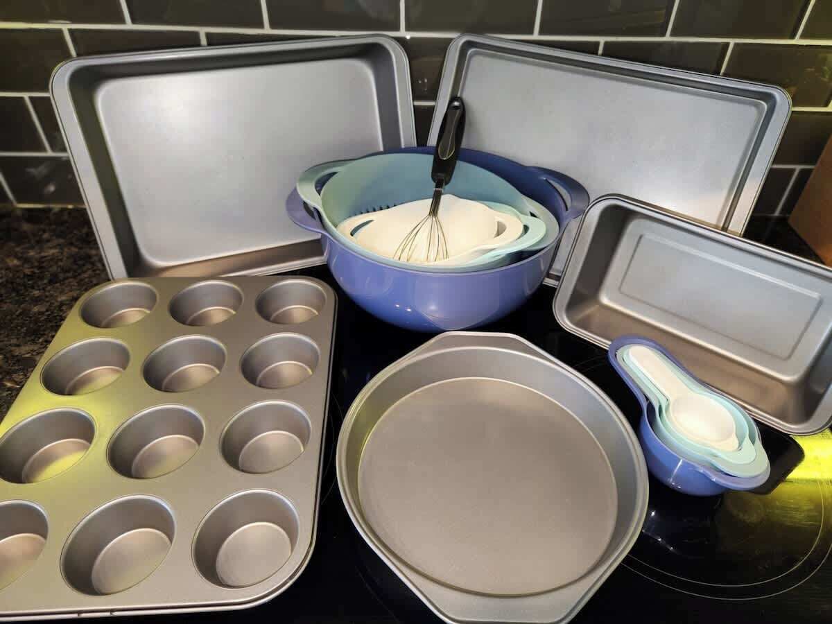 Een keuken met een muffinvorm, een blauwe mengkom en een ronde bakvorm.