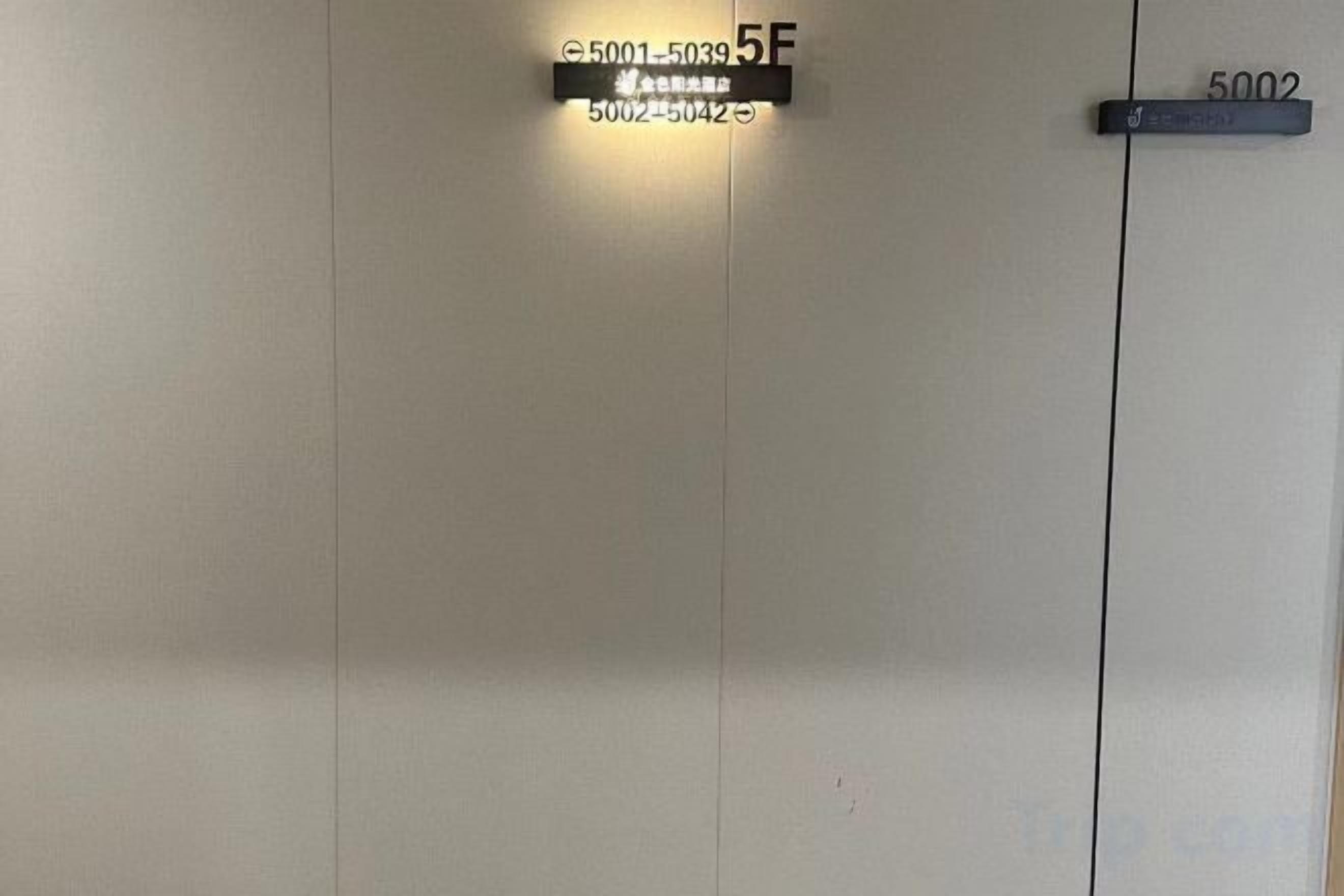 A door with a sign indicating room number 5F and another sign with the number 5002.