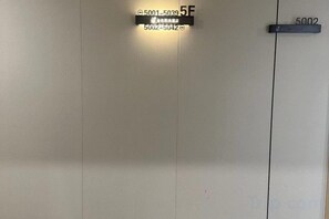 A door with a sign indicating room number 5F and another sign with the number 5002. - Jinse Sunshine Hotel (Baicheng)