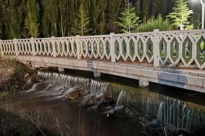 A bridge with a decorative railing over a flowing stream. - Jinse Sunshine Hotel (Baicheng)