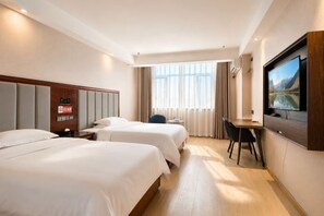 A hotel room with two beds, a desk, a television, and a window with curtains. - Jinse Sunshine Hotel (Baicheng)