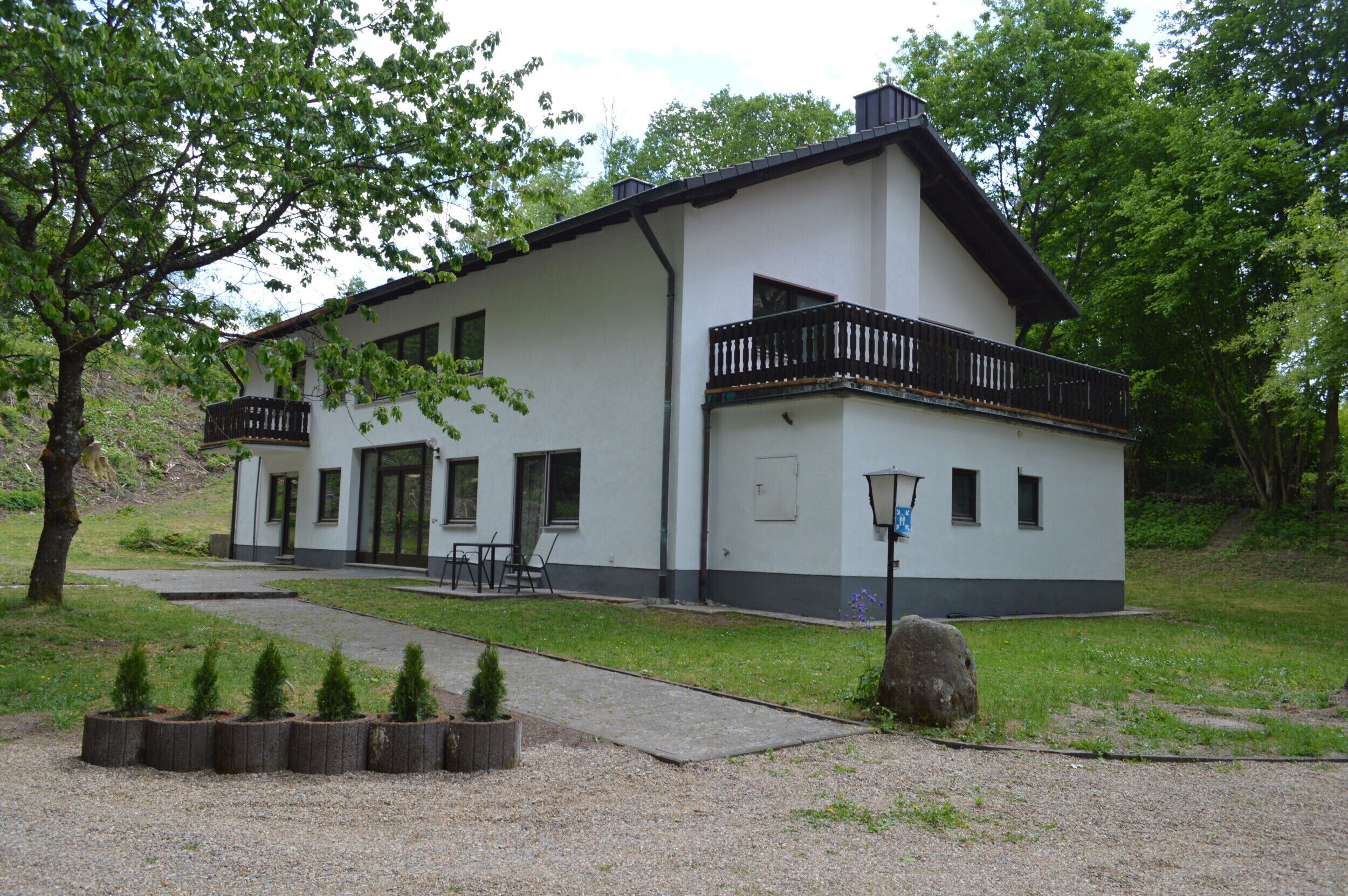 A two-story building with a balcony, a front door, and a small porch area.