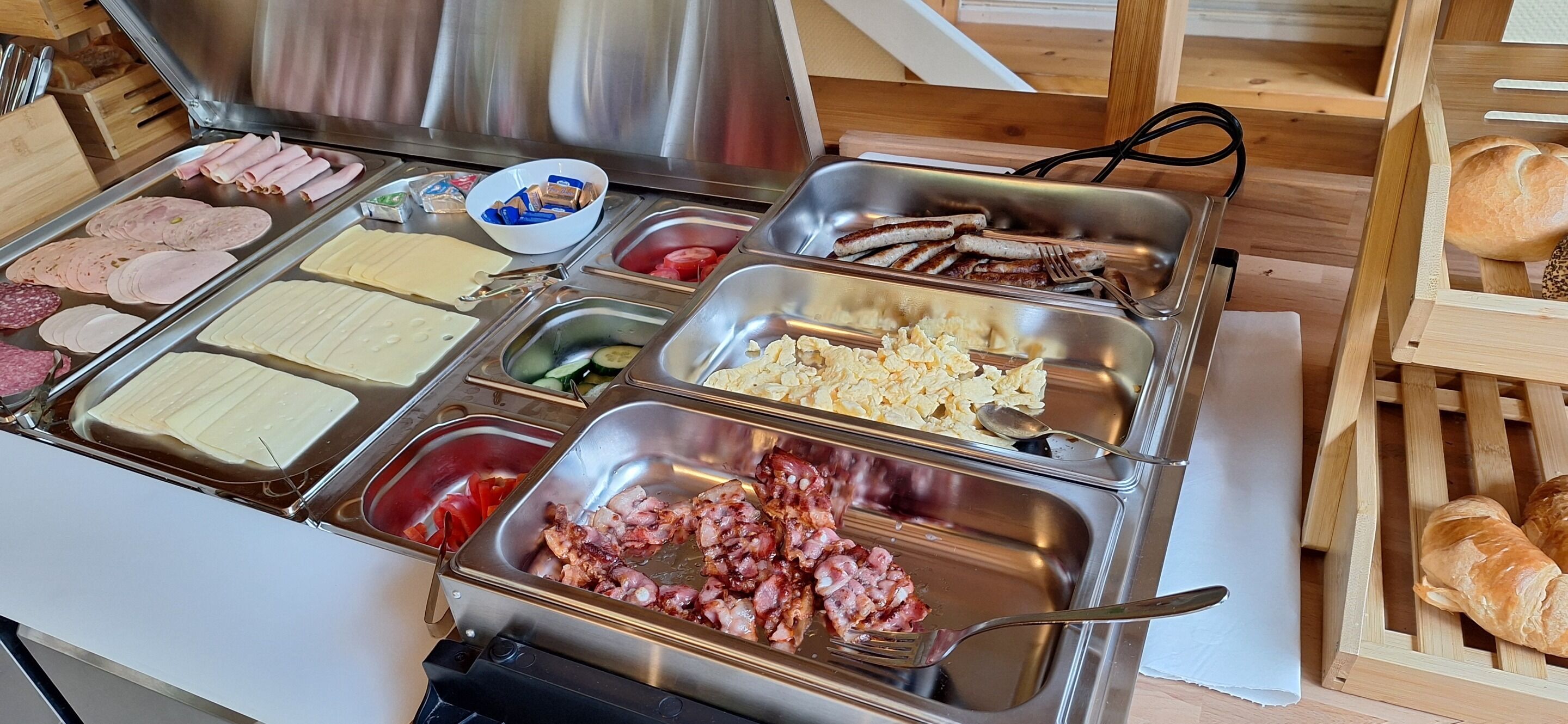 Ein Buffet mit verschiedenen Speisen, darunter Fleisch, Käse und Gemüse.