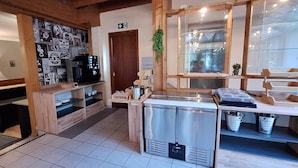 A cozy cafe with wooden decor, a coffee machine, and a view through a large window. - Hotel am Park (Bad Brueckenau)