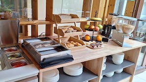 A buffet setup with various food items and serving utensils. - Hotel am Park (Bad Brueckenau)