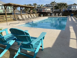 A pool area with blue Adirondack chairs, a wooden deck, and a pool with a 3 FT depth marking. - Sunday Villas Sunday Funday by Silver Sands Vacation Rentals (Port Aransas)