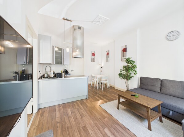 A modern living space with a kitchen, dining area, and seating area.