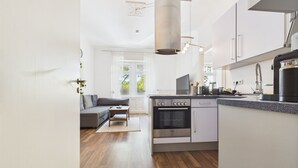 Una cocina moderna con armarios blancos, un horno Bosch y una cafetera.
