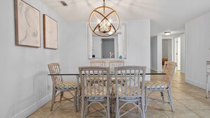 A dining area with a round table, wicker chairs, and a unique chandelier. - 2BR Golf View Villa Near Beach in Sea Pines Resort (Hilton Head Island)