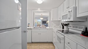 A modern kitchen with white cabinetry, a built-in oven, and a microwave. - 2BR Golf View Villa Near Beach in Sea Pines Resort (Hilton Head Island)