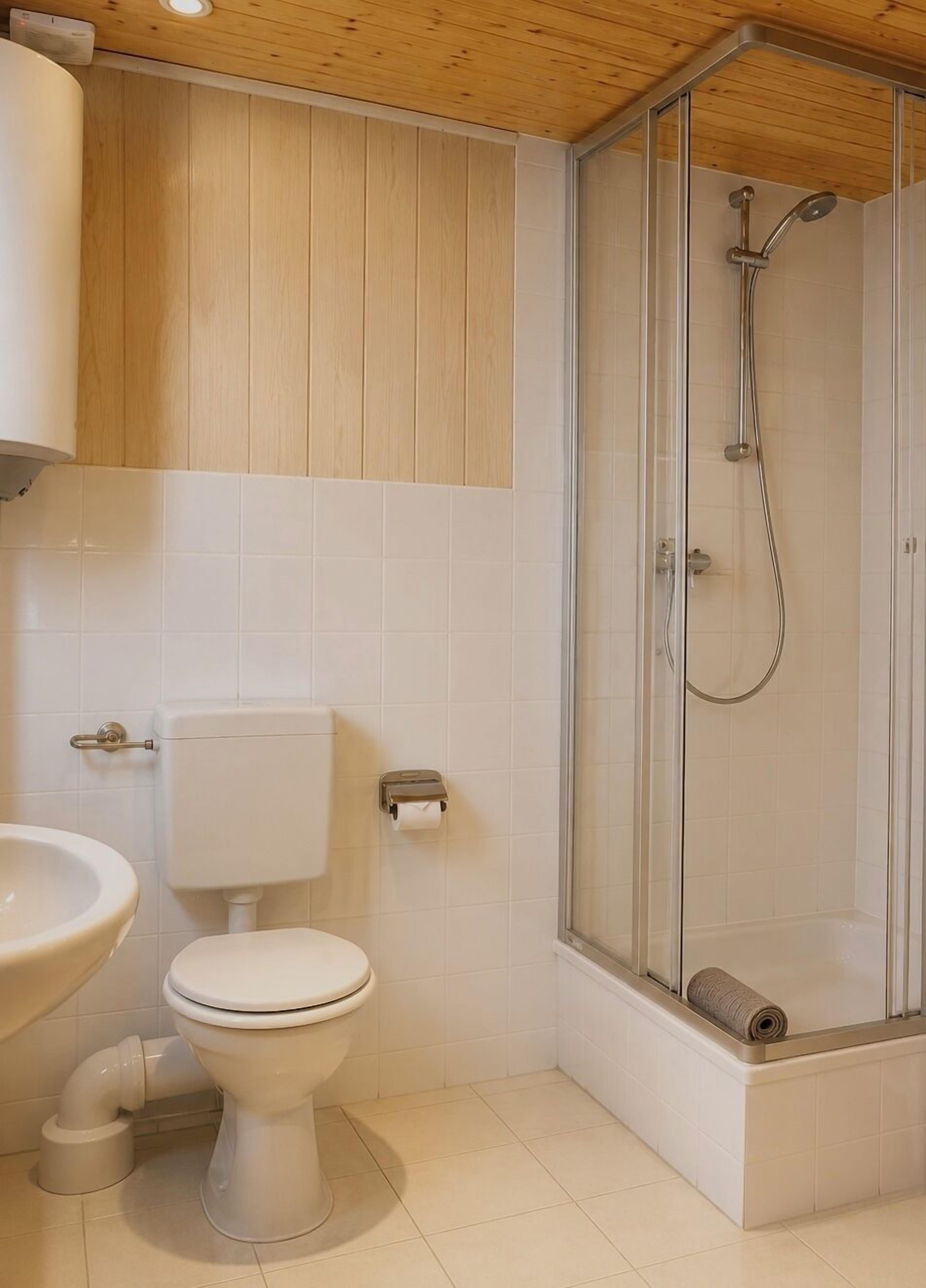 A bathroom with a toilet, sink, and shower.
