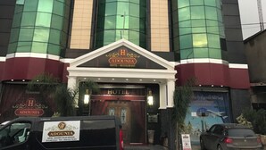 Un hôtel avec une grande enseigne indiquant « HÔTEL » et une plus petite enseigne en dessous indiquant « RÉSTAURANT DE L’HÔTEL ADOUNIA ».