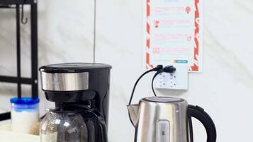 A coffee maker and a kettle on a kitchen counter.