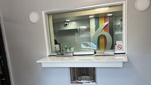 A room with a window, a white shelf, a colorful striped rug, and a large number '6' on the wall. - Motel 6 - Chicago, IL (Chicago)