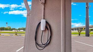Een parkeergarage met een Tesla-laadstation op een pilaar.