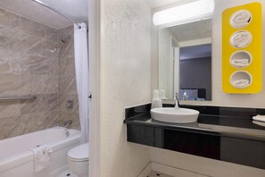 Bañera con ducha, toallas, papel higiénico